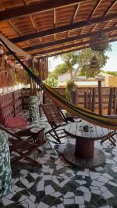 a hammock on a patio with chairs and a table at Hopa Shelter Surf House Apartamento in Paracuru