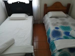 dwa łóżka siedzące obok siebie w pokoju w obiekcie Casa Los Ángeles w mieście Ángeles