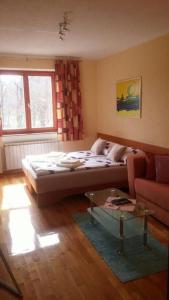 a bedroom with a bed and a couch and a table at GABY apartment-center of Plitvička Jezera in Plitvička Jezera