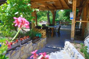 a patio with a table and chairs and flowers at Apartment Green Lagoon in Bihać