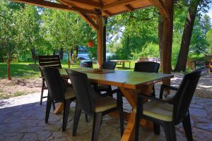 a wooden table and chairs under a gazebo at Apartment Green Lagoon in Bihać