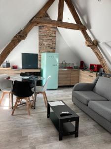 Flines-lès-Mortagne的住宿－Au cochon qui rit，带沙发的客厅和厨房