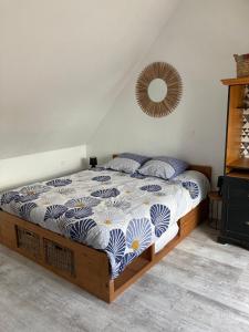 um quarto com uma cama com um edredão azul e branco em Au cochon qui rit em Flines-lès-Mortagne