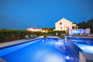 una piscina frente a una casa en Villa Pino with Pool, Sauna & Jacuzzi en Petrcane
