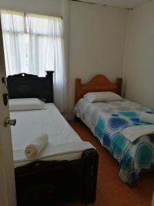 Ángeles的住宿－Casa Los Ángeles，一间卧室设有两张床和窗户。