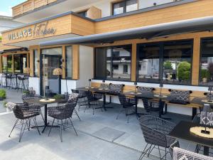 a restaurant with tables and chairs in front of it at Dahoam by Sarina - Village Appartements in Zell am See