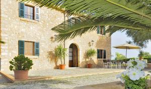 a house with plants and an umbrella in front of it at Finca Son Burguet 010 by Mallorca Charme in Llubí