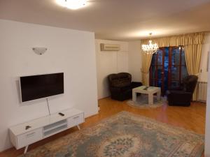 ein Wohnzimmer mit einem Flachbild-TV an der Wand in der Unterkunft Villa Kuna in Sarajevo