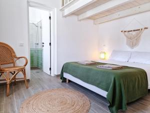a white bedroom with a bed and a chair at CASA VERDE - Beach House, Private Terrace & Pool in Benagil +35 photos