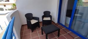 2 sedie e un tavolo sul balcone di RESIDENCIAL LOS PATOS PLAYA a Benalmádena