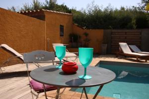 a table with two glasses on it next to a pool at SUITE SPA PRIVATIF extérieur 66 Perpignan Nord in Pia