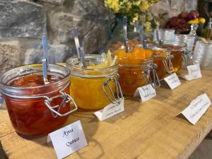 three jars of honey on a wooden table with signs at Hotel Kalehan in Selçuk