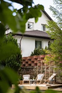 a couple of chairs and a table in front of a house at Agroturystyka Święty Spokój in Wünschelburg