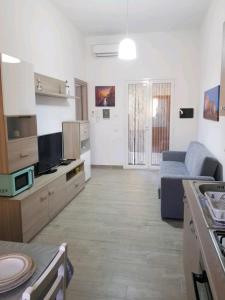ein großes Wohnzimmer mit einem Sofa und einer Küche in der Unterkunft casa vacanze Rosanna in Balestrate