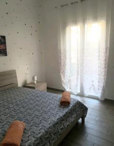 ein Schlafzimmer mit einem Bett und einem großen Fenster in der Unterkunft casa vacanze Rosanna in Balestrate