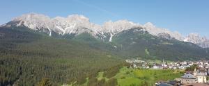 a small town in front of a mountain range at Appartamento panoramico 1 in Dosoledo