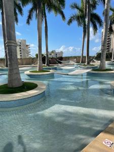 a swimming pool with palm trees in a resort at Four Seasons Hotel Miami - Luxury Private Residences in Miami