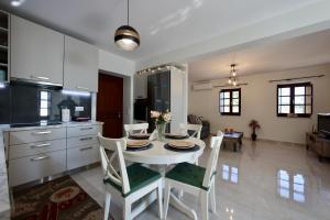 a kitchen and dining room with a white table and chairs at Sunset View Stone House, Areopoli Mani in Areopolis