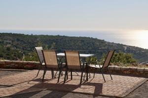 a table and chairs sitting on top of a patio at Sunset View Stone House, Areopoli Mani in Areopolis