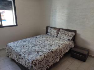 uma cama num pequeno quarto com uma roupa de cama espectrosespectrosspectos em Nice appa em Kenitra