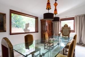 a dining room with a glass table and chairs at Domus Orestea Luxury Suites in Palermo