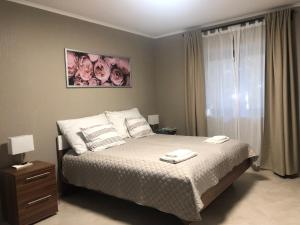a bedroom with a bed and a window with roses at Second Home Apartments Miskolctapolca in Miskolctapolca
