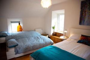 a bedroom with two beds and two windows at Cosy Apartment/ Explore The Area/Enjoy our Pub in Headford