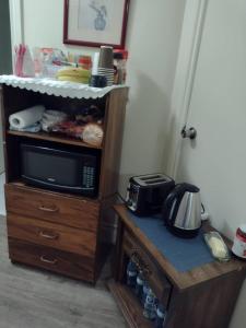 a microwave on top of a wooden stand with a counter at Village at York U in Toronto
