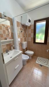 a bathroom with a sink and a toilet and a window at Baia Aurora in Letojanni