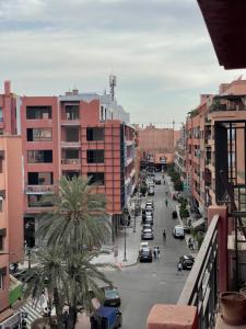 une rue de la ville avec des palmiers et des bâtiments dans l'établissement Lovely 1BR apartment with free parking in gueliz, à Marrakech