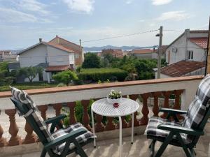 a balcony with two chairs and a table on a balcony at Rooms Margarita in Zadar