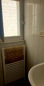 ein Bad mit einem Fenster und einem Handtuchhalter neben einem Waschbecken in der Unterkunft HOUSE AURORA 50 in Ostuni