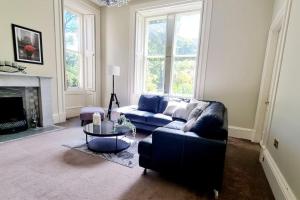 uma sala de estar com um sofá e uma lareira em Luxury 5-bed Villa - Winfields House em Prestonpans