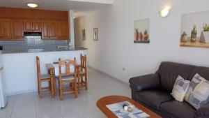 ein Wohnzimmer mit Sofa und Tisch in der Unterkunft Apartments Casa Blanca in Charco del Palo + 9 Fotos