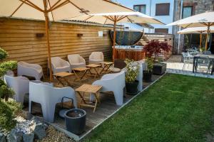 eine Terrasse mit Stühlen, Tischen und Sonnenschirmen in der Unterkunft LA GLORIETTE in Marche-en-Famenne