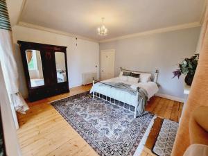 a bedroom with a bed and a rug at Luxury 5-bed Villa - Winfields House in Prestonpans