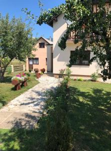 a house with a tree and a walkway at Apartment Arya in Korenica