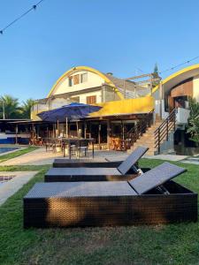 a building with tables and chairs in front of it at Pousada Solarium-UNIDADE 2 - HOTEL BOUTIQUE in Guarujá