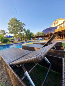 a hammock sitting next to a swimming pool at Pousada Solarium-UNIDADE 2 - HOTEL BOUTIQUE in Guarujá