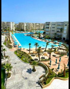 a resort with a large pool with palm trees and buildings at Palm Lake Resort Folla Monastir/Sousse in Monastir