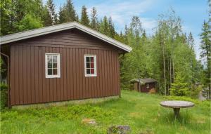 a small brown building in the middle of a field at Awesome Home In Hurdal With 2 Bedrooms in Hurdal