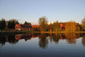 un gran lago con una casa en el fondo en Siedlisko Konradówka, en Olecko