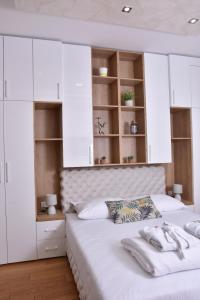 a bedroom with two white beds and white cabinets at Frajla in Novi Sad