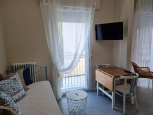 a living room with a couch and a table and a window at Residenza Azzurra in Cattolica