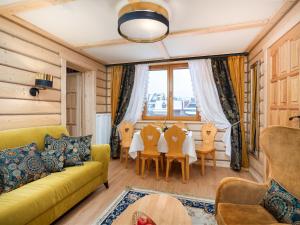 a living room with a yellow couch and a table at ECO Villa Karpatia Ski&SPA in Murzasichle