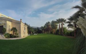 un gran patio con palmeras y un edificio en Orange Tree Garden vacation home, en Ayiá