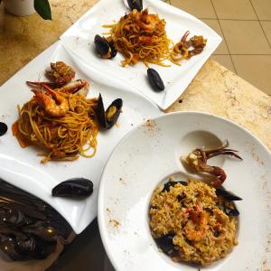 dos platos de comida con marisco y arroz en una mesa en Kompleksi Turistik EDIR, en Orikum