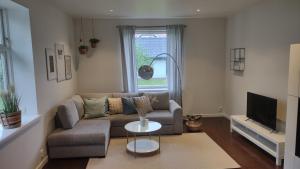 uma sala de estar com um sofá e uma mesa em Bambina's Guest House em Kristianstad