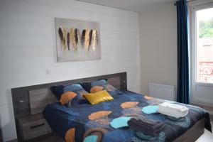 a bedroom with a bed with a blue comforter at Superbe T3 classé 3 étoiles Chez Cathy et Frank situé en plein centre de Gérardmer in Gérardmer