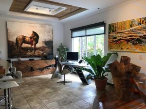 una oficina con escritorio y una pintura de un caballo en Palm Coast Luxury Rentals, en Esterillos Este